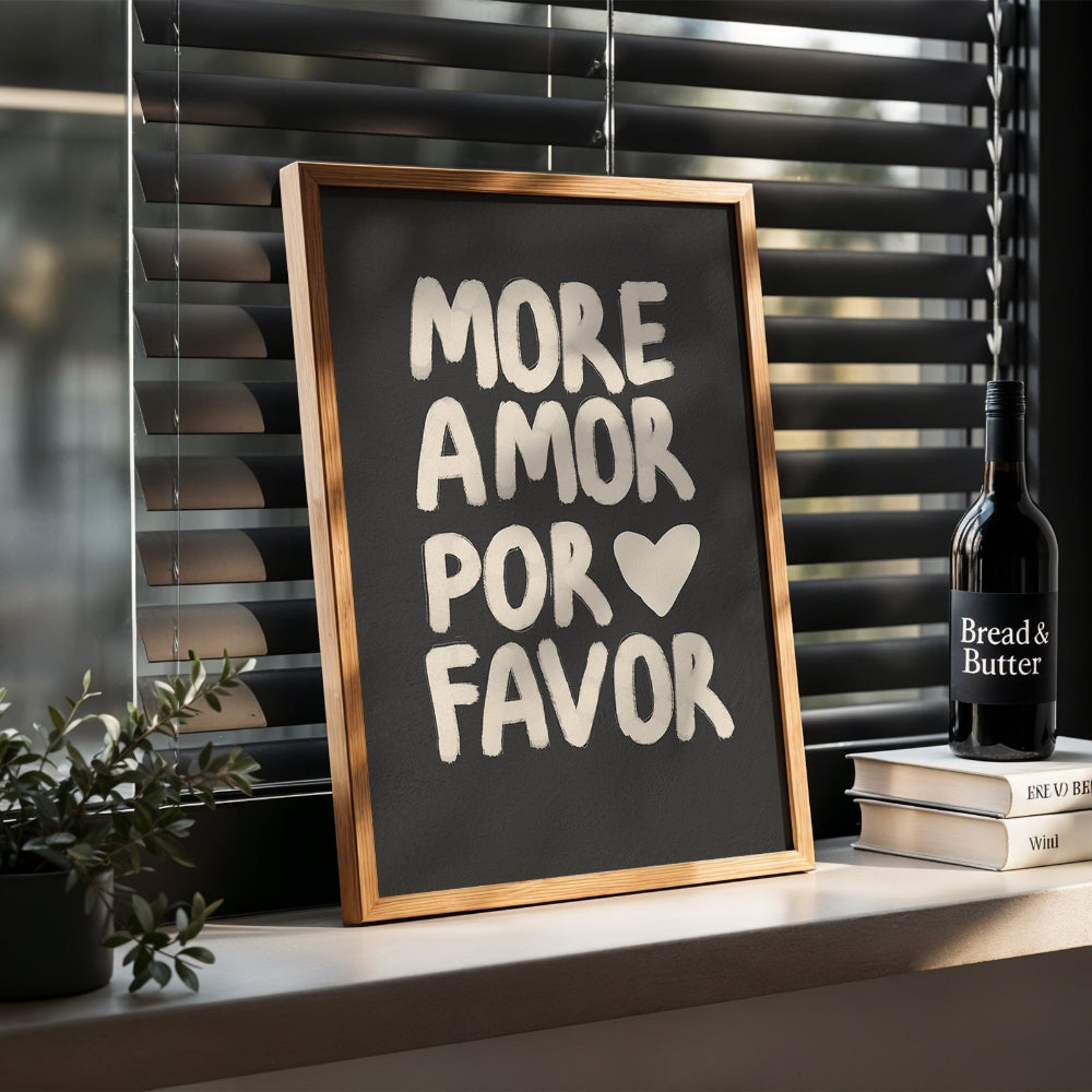 Framed poster with 'More Amor Por Favor' text on a shelf with books and a bottle.