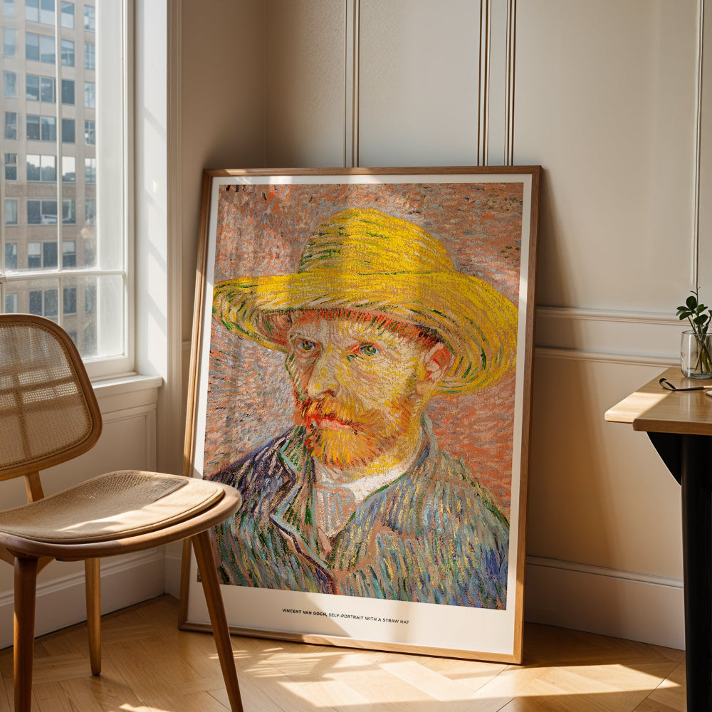 Framed artwork of a self-portrait of Vincent Van Gogh with a yellow hat in a room with a chair and window.